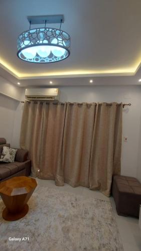 a living room with a curtain and a chandelier at Eamar tower 2 in Tanta