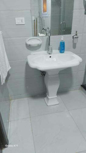 a white bathroom with a sink and a mirror at Eamar tower 2 in Tanta