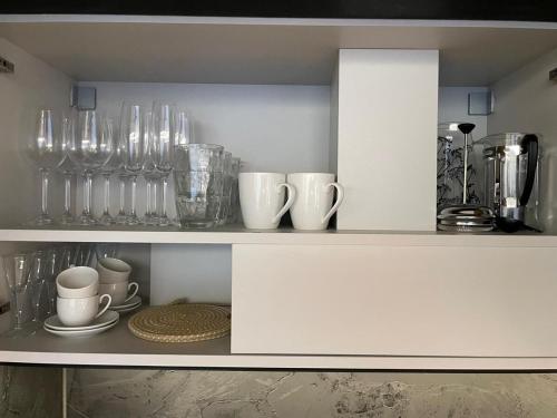 a shelf with glasses and other items on it at Premium Apartment with Terrace in Central Palanga in Palanga