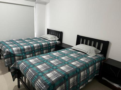 a bedroom with two beds and a window at Departamento en Residencial in Mexico City