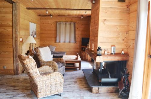 - un salon avec une cheminée dans une cabane en rondins dans l'établissement Chalet familial - Pyrénées, au cœur des 3 stations, à La Cabanasse