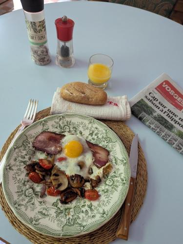 ein Teller mit Essen und einem Ei auf einem Tisch in der Unterkunft La Maison de Marie in Les Rouges-Eaux