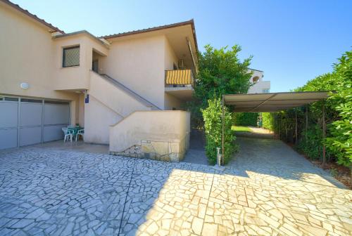 a house with a patio with an umbrella at Apartmani Kirinčić in Krk