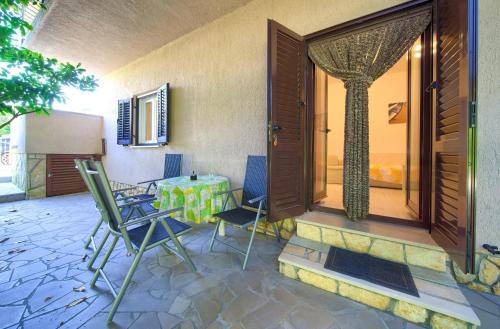 a patio with chairs and a table and a window at Apartmani Kirinčić in Krk