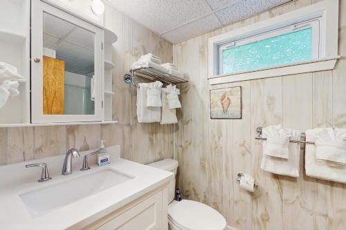 a bathroom with a sink and a toilet and a window at Birch Circle Beach House in Ogunquit