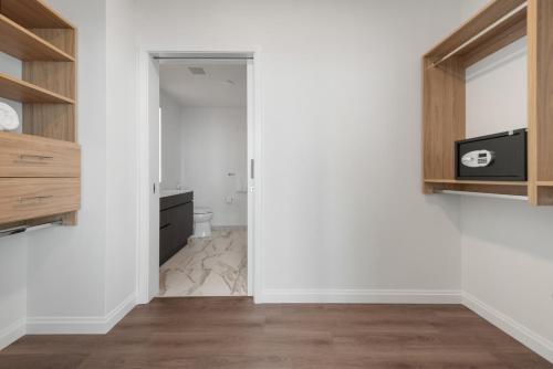 a bathroom with white walls and wooden cabinets at Lux Apts with Lake Views and Top Amenities in Chicago