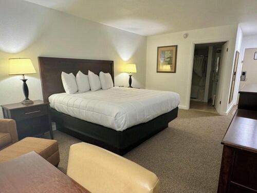 a hotel room with a bed and a living room at Heritage Hotel of Quincy in Quincy