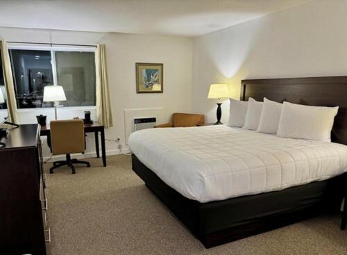 a hotel room with a bed and a desk at Heritage Hotel of Quincy in Quincy