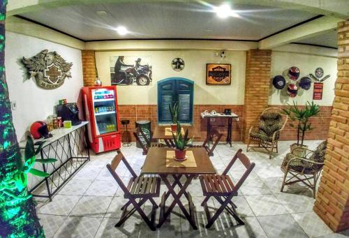 a dining room with a table and chairs and a refrigerator at Portal Suítes Casa do Lago in Paraty