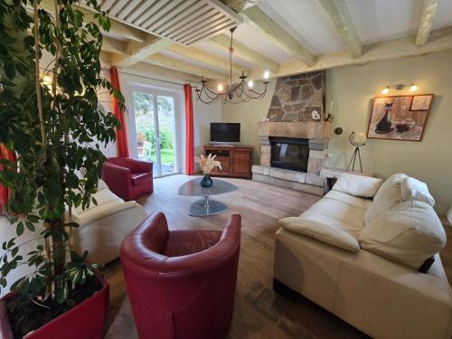 a living room with a couch and a fireplace at Authentique maison bretonne avec jardin fleuri in Saint-Thonan