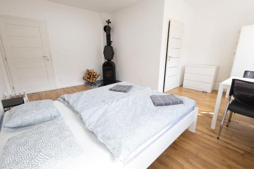 a bedroom with a white bed and a table and chairs at Ubytovanie Poloniny in Zboj