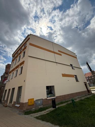 a white building with brown stripes on the side of it at Apartament 11 na 10 in Głuchołazy