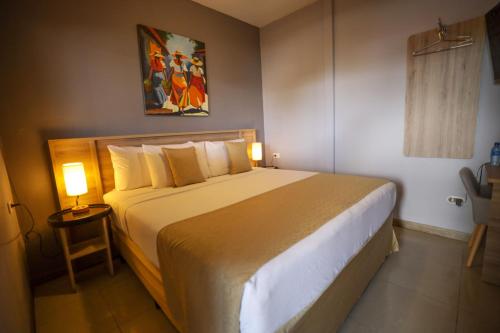 a bedroom with a large bed in a room at Hotel Los Altos Express "La Centroamerica" in Managua