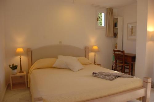 a bedroom with a bed with two lamps and a table at Naxos Beachvilla in Plaka