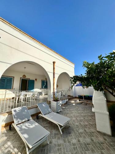 a patio with two lounge chairs and a building at Villetta Piera in Mazara del Vallo
