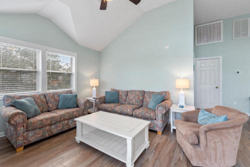 a living room with two couches and a coffee table at Dream23 in Corolla