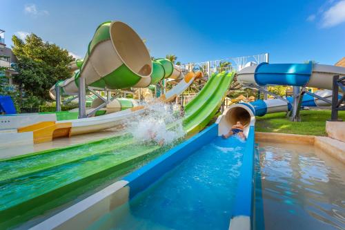 a child sliding down a water slide at a water park at Sandos Caracol Nature Resort & Water Park All Inclusive in Playa del Carmen