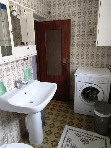 a bathroom with a sink and a washing machine at La Casa D in Rocchetta SantʼAntonio