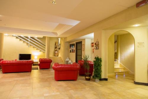 a lobby with red couches and a tv and stairs at Albergo della Posta in Taverna