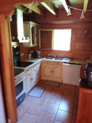 une cuisine avec des armoires blanches et un four à plaques de cuisson dans l'établissement chalet Leon, à Basse-sur-le-Rupt