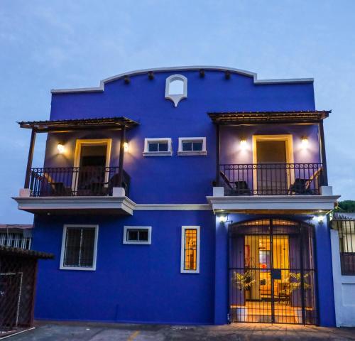 a blue house with a balcony in front of it at Hotel Los Altos Express "La Centroamerica" in Managua