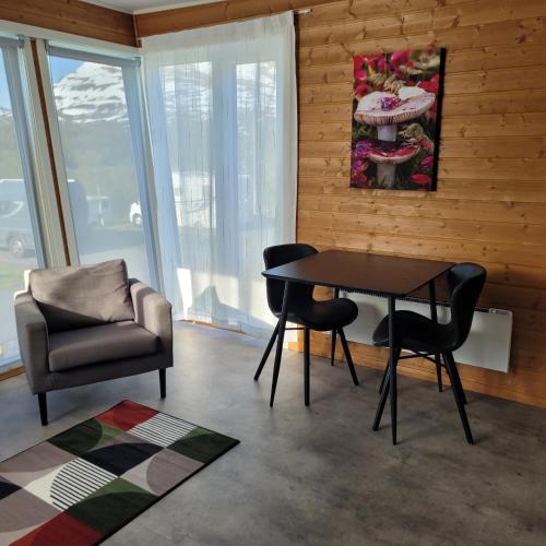 a dining room with a table and two chairs at Lapphaugen Turiststasjon in Tennevoll