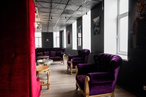 a waiting room with purple chairs and a table at Hedgehogs backpackers hostel in Rīga