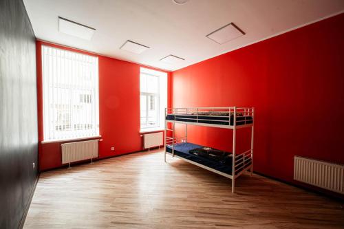 an empty room with red walls and a bunk bed at Hedgehogs backpackers hostel in Rīga