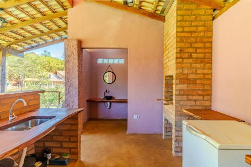 cocina con fregadero y pared de ladrillo en Quinta da Baronesa 2 - Sapucai Mirim, en Sapucaí-Mirim