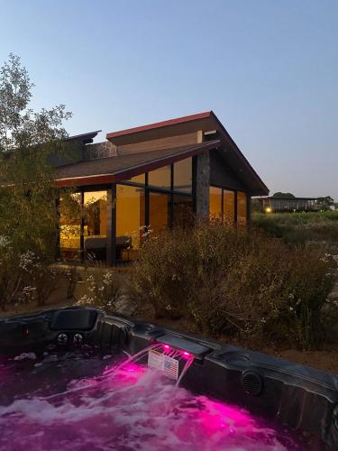 a hot tub in front of a house with pink lights at Cabañas by 7 Valles in Valle de Guadalupe