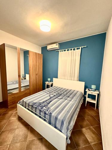 a bedroom with a bed and a blue wall at Villetta Piera in Mazara del Vallo