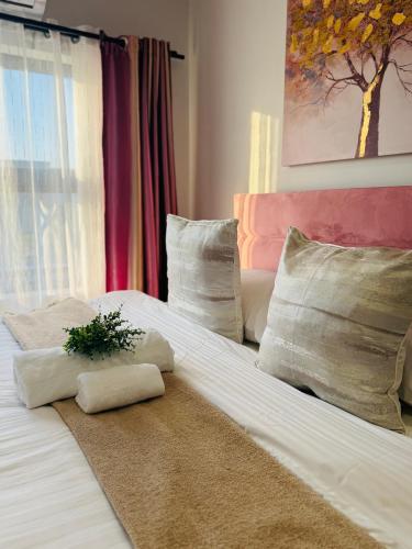 a bed with two towels and a plant on it at Enzo - Sarona City in Gaborone