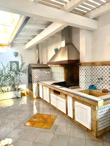 a large kitchen with a stove and a sink at Villetta Piera in Mazara del Vallo