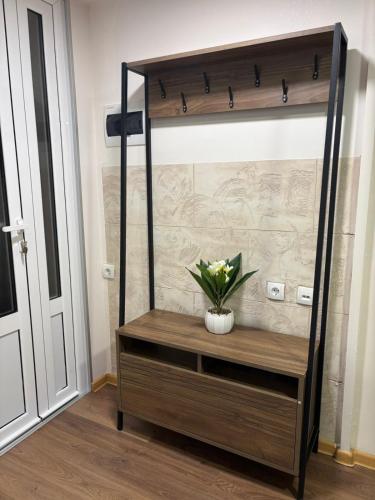 a wooden shelf with a vase of flowers on it at Apartmani Krivokuća in Sveštica