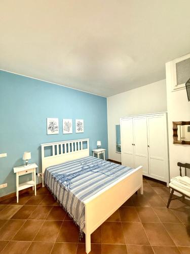 a bedroom with a bed and a blue wall at Villetta Piera in Mazara del Vallo