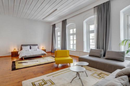 a living room with a bed and a yellow chair at Kois Loft in Ermoupoli