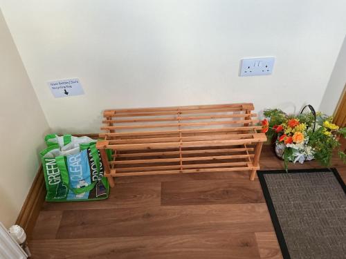 a wooden bench sitting in a room with flowers at Riverside Retreat in Caol
