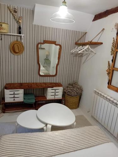 a room with two white tables and a mirror at La casa del confitero in Rueda