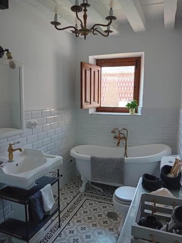 a bathroom with a tub and a toilet and a sink at La casa del confitero in Rueda