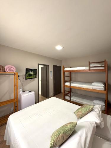 a bedroom with a bed and bunk beds at Hostel Costa Terral in Matinhos