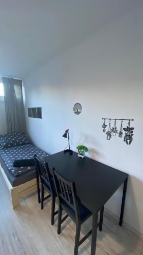 a black table with chairs and a bed in a room at Rooms in Warsaw - G9 in Warsaw