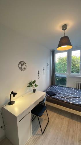 a room with a desk and a bed with a window at Rooms in Warsaw - G9 in Warsaw