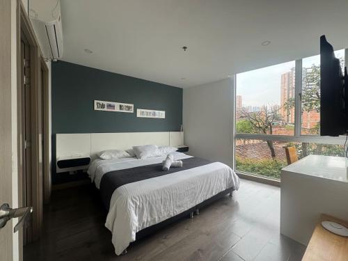a bedroom with a large bed and a large window at S406 Studio w Rooftop Pool Jacuzzi El Poblado in Medellín