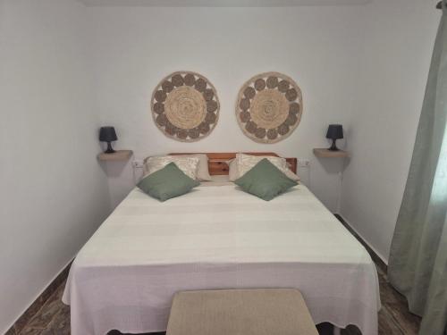 a bedroom with a white bed with two pillows at Luz del Mar in Orzola