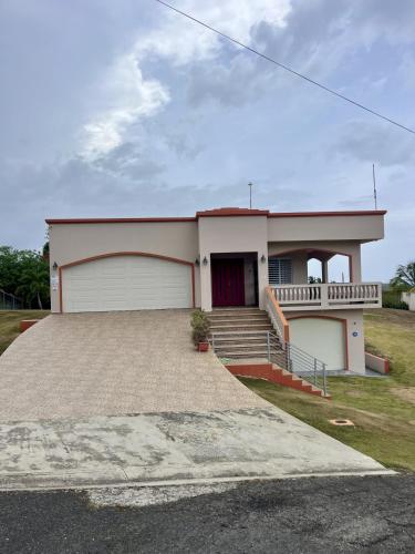 a house with a garage and a driveway at Ocean View House in Quebradillas with Rooftop 