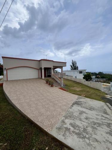 a house with a garage and a driveway at Ocean View House in Quebradillas with Rooftop 