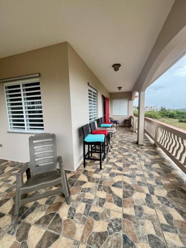 a porch with chairs and tables on a balcony at Ocean View House in Quebradillas with Rooftop 