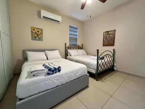 a bedroom with two beds with towels on them at Ocean View House in Quebradillas with Rooftop 