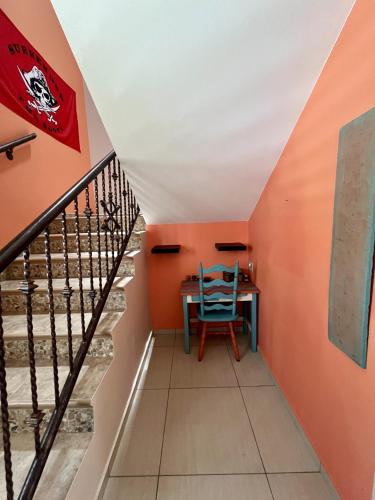 a staircase with a table and a blue chair at Ocean View House in Quebradillas with Rooftop 