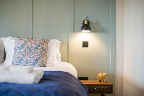 a bed with a pillow and a lamp on a table at The Rowen at The Balfour by Coorie Doon Stays in Coaltown of Balgonie